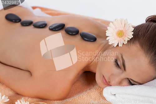 Image of attractive healthy caucasian woman hot stone massage wellness 