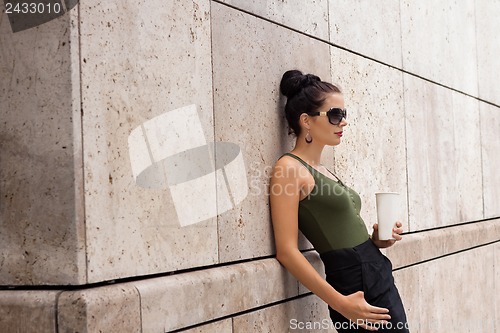 Image of attractive young woman with smartphone and sunglasses outdoor