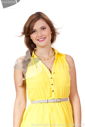 Image of smiling young brunette woman in yellow dress isolated