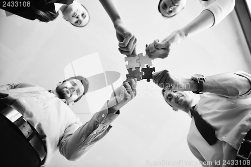 Image of Group of business people assembling jigsaw puzzle