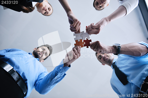 Image of Group of business people assembling jigsaw puzzle