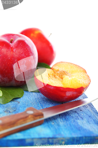 Image of Ripe plums and knife.