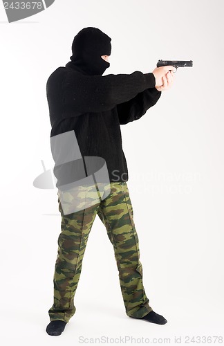 Image of masked man aims with gun