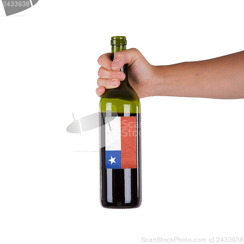 Image of Hand holding a bottle of red wine