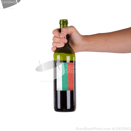 Image of Hand holding a bottle of red wine