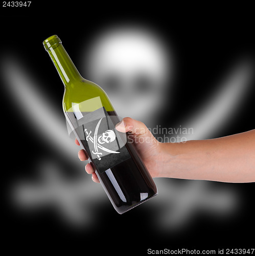 Image of Hand holding a bottle of red wine