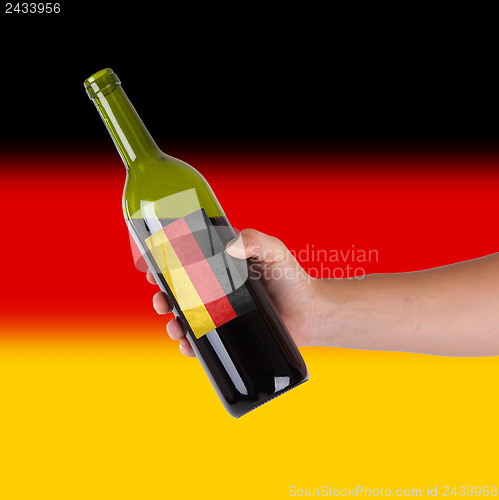 Image of Hand holding a bottle of red wine