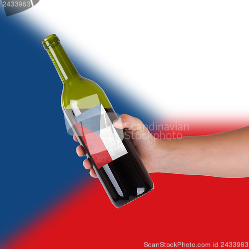 Image of Hand holding a bottle of red wine