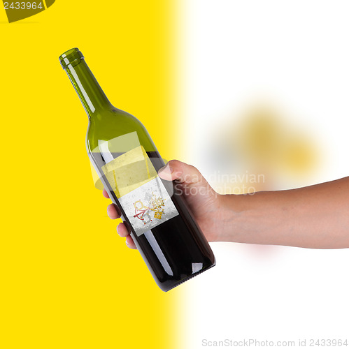 Image of Hand holding a bottle of red wine