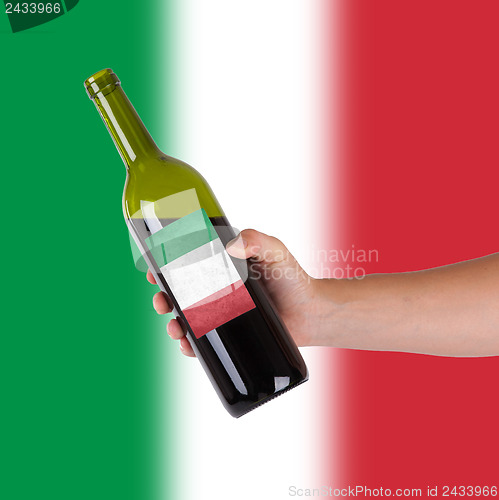 Image of Hand holding a bottle of red wine