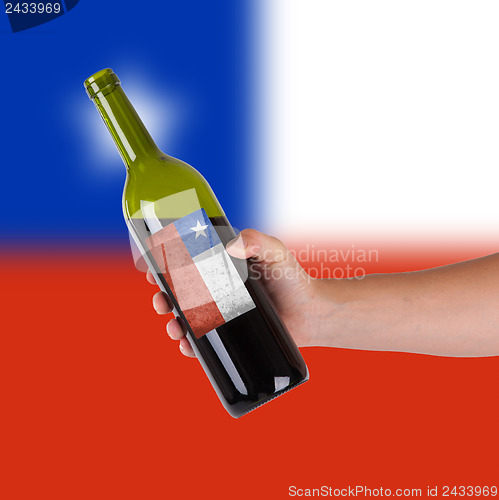 Image of Hand holding a bottle of red wine