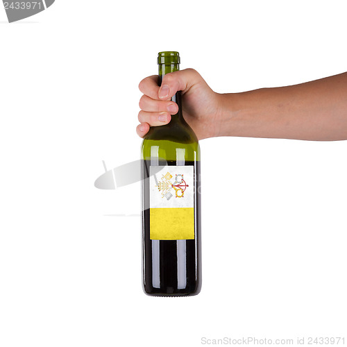 Image of Hand holding a bottle of red wine