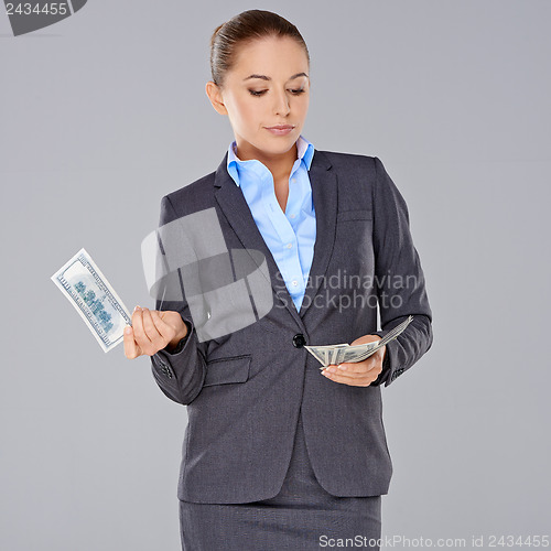 Image of Stylish businesswoman holding dollar bills