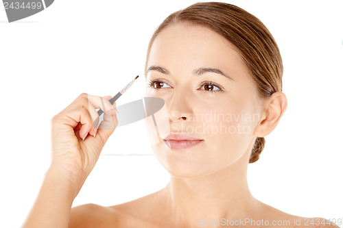 Image of Beautiful woman with a small cosmetics brush