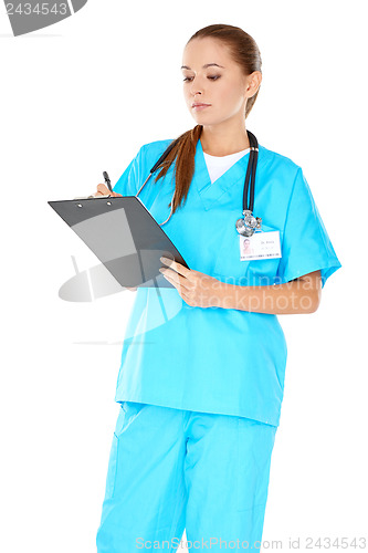 Image of Pretty young nurse writing up notes