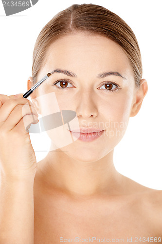 Image of Woman holding a tiny cosmetic brush