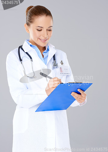 Image of Doctor writing on a patients file