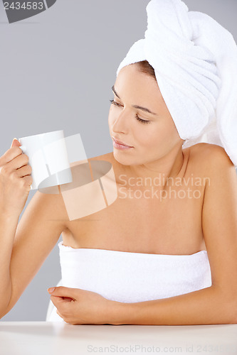 Image of Woman at a spa looking at a mug of coffee