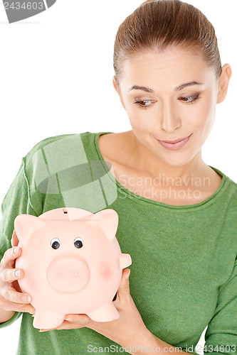 Image of Woman giving her piggy bank a speculative look