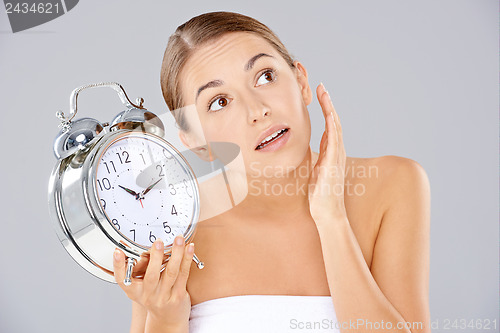 Image of Woman holding an alarm clock