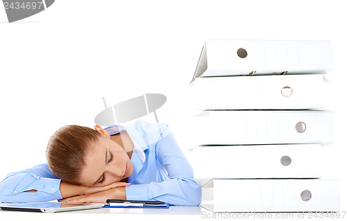 Image of Tired businesswoman asleep at her desk