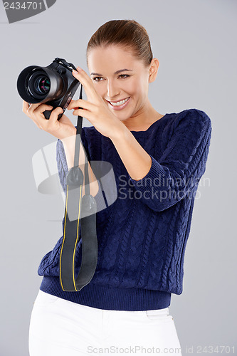 Image of Happy woman holding a professional camera