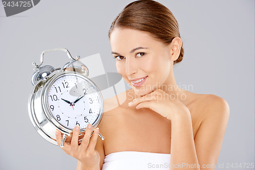 Image of Woman holding an alarm clock