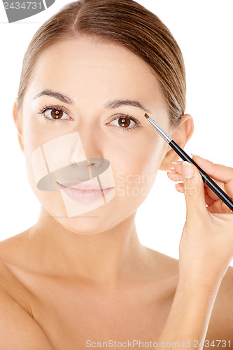 Image of Woman holding a tiny cosmetic brush