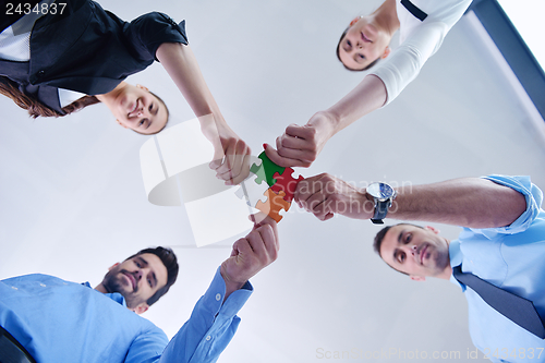 Image of Group of business people assembling jigsaw puzzle