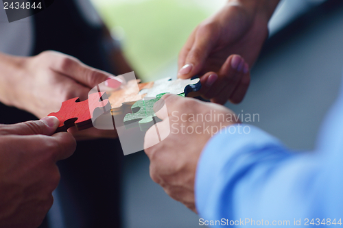 Image of Group of business people assembling jigsaw puzzle