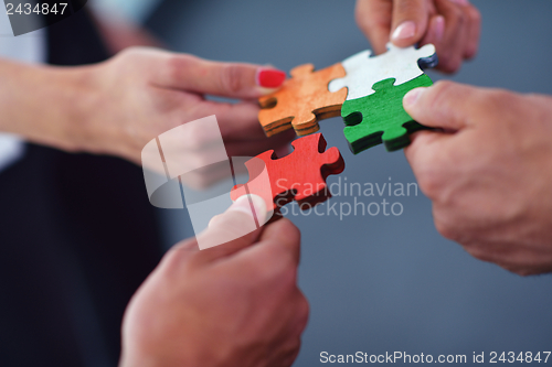 Image of Group of business people assembling jigsaw puzzle