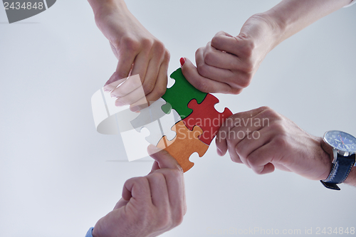 Image of Group of business people assembling jigsaw puzzle