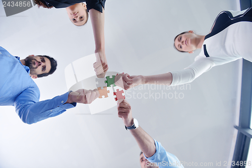 Image of Group of business people assembling jigsaw puzzle