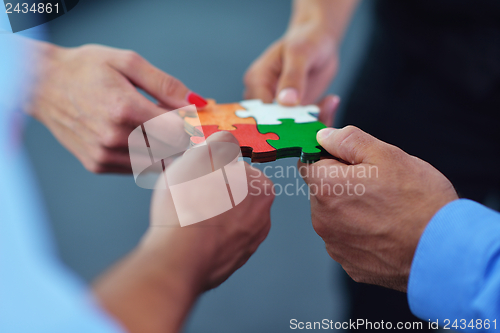 Image of Group of business people assembling jigsaw puzzle