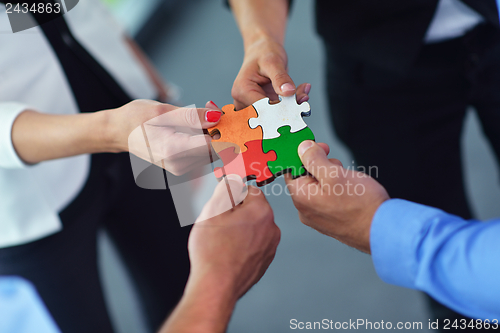 Image of Group of business people assembling jigsaw puzzle