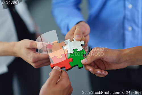 Image of Group of business people assembling jigsaw puzzle