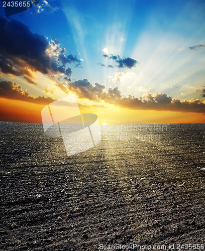 Image of sunset over black field