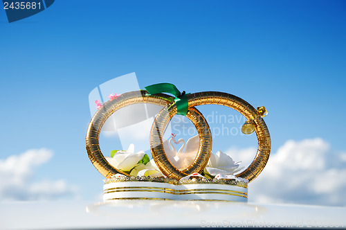 Image of golden weddings rings over car