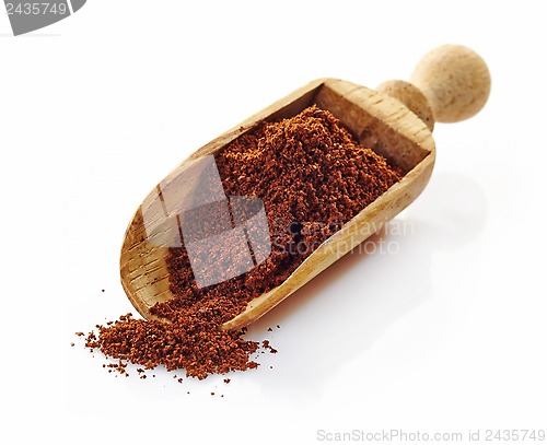 Image of wooden scoop with ground coffee