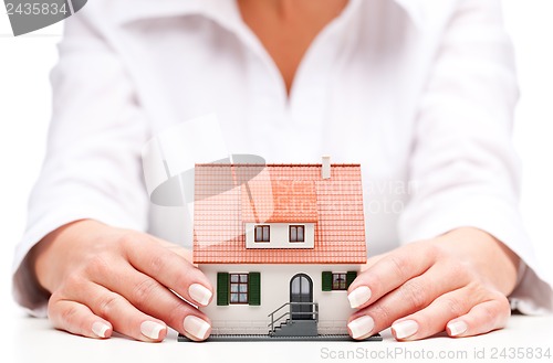 Image of pisture of man and woman hands holding paper house