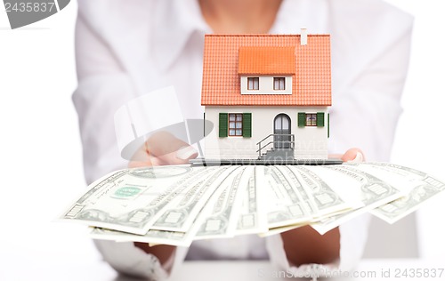 Image of Hands with money and miniature house on a white background