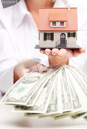 Image of Hands with money and miniature house on a white background