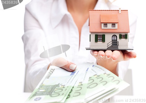 Image of Little house toy and money in woman's hands