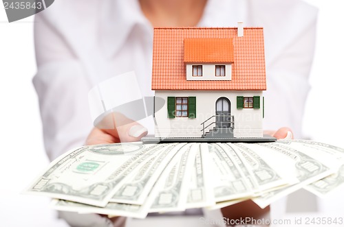 Image of Hands with money and miniature house on a white background