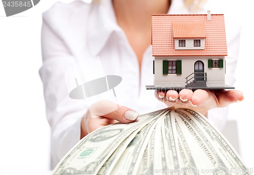 Image of Hands with money and miniature house on a white background