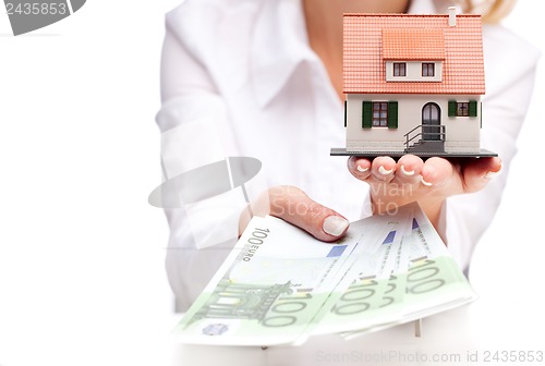 Image of Little house toy and money in woman's hands