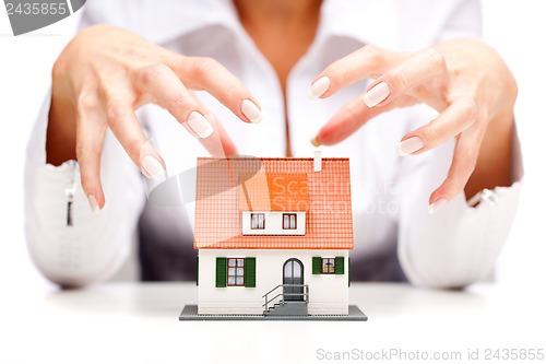 Image of Female hands and small house