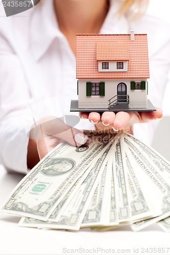 Image of Hands with money and miniature house on a white background