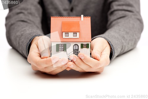 Image of Hands holding a small house