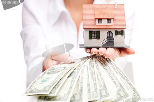 Image of Hands with money and miniature house on a white background